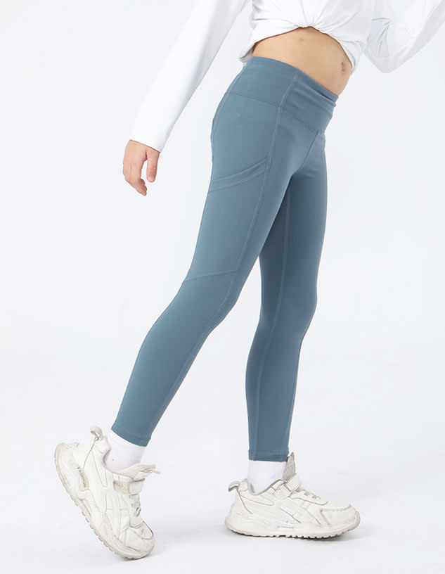 A pair of girl's leggings in a soft blue colour, featuring a fitted design and side pockets.