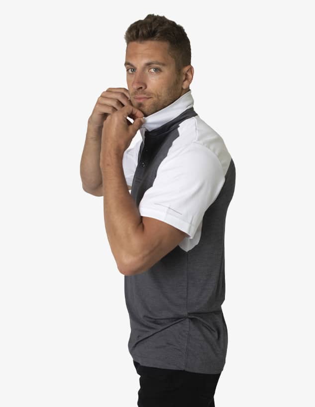 A polo shirt in grey and white with a collar being adjusted by a model. The shirt features a logo on the chest.