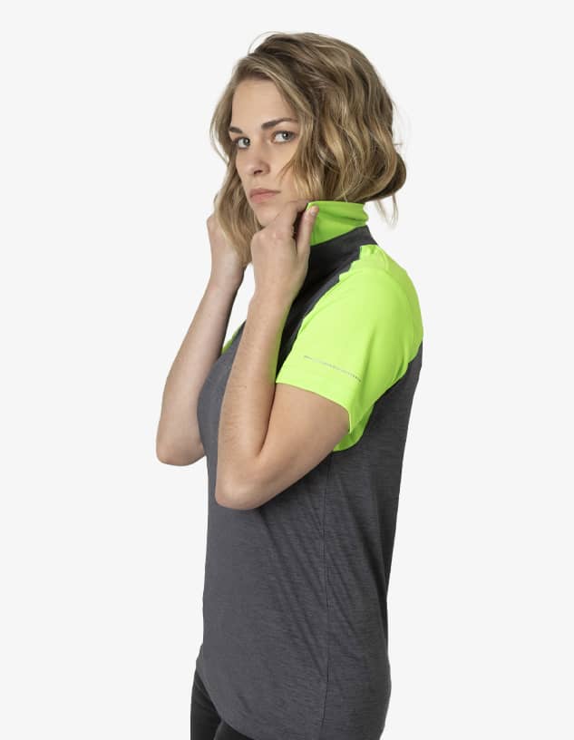 A polo shirt featuring a grey body and bright green sleeves, with a collar being adjusted by a model.