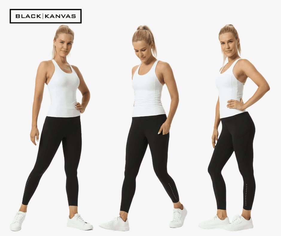 A pair of black leggings displayed on a model, featuring a logo, worn with a white tank top and white footwear.