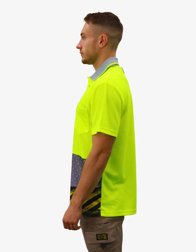 A bright yellow polo shirt features a contrasting blue-grey lower section with a logo. Side view on a model.