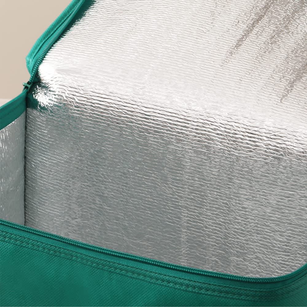 A drink bottle in a green carrier with a reflective silver interior visible inside.