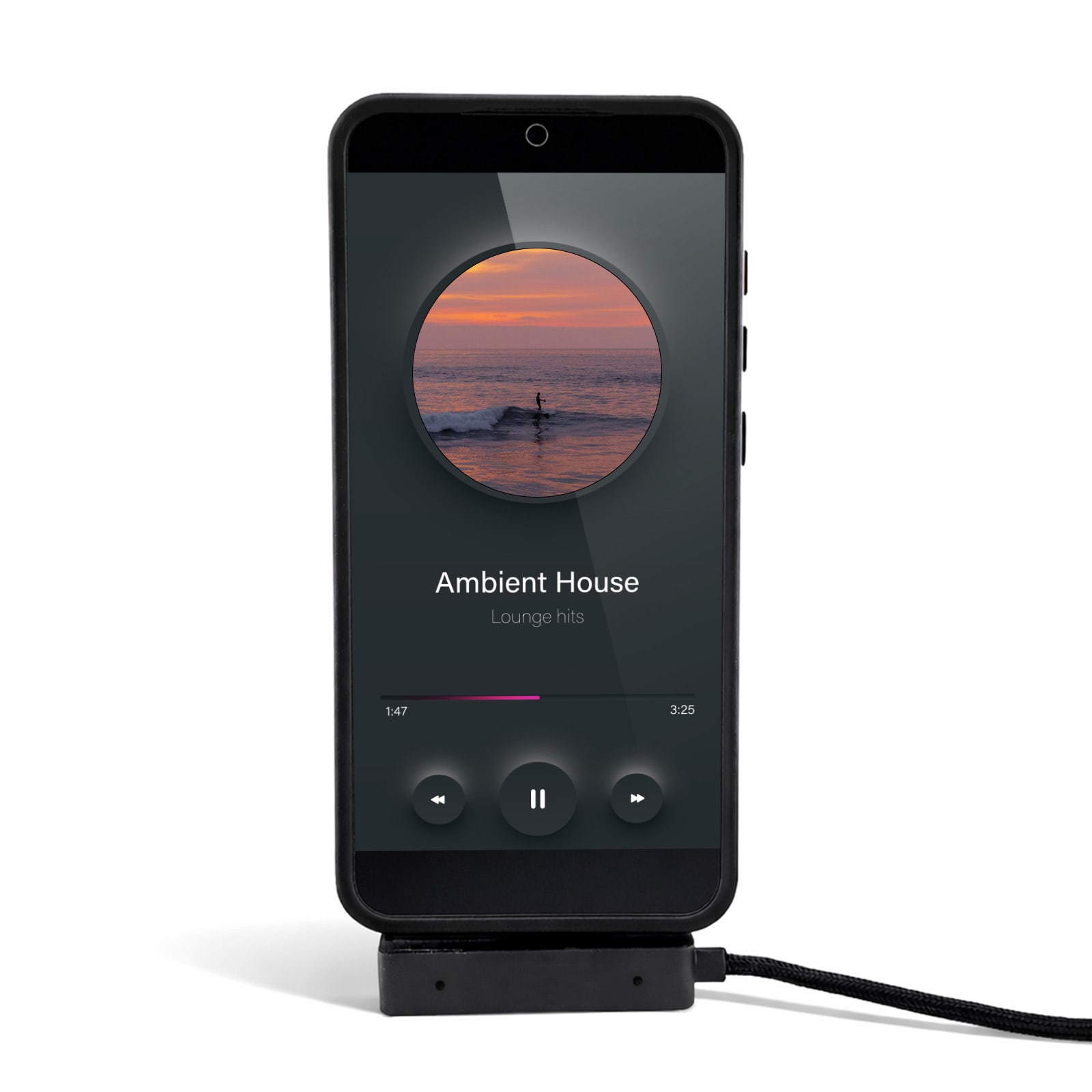 A black phone on a stand displaying a music player interface with a charging cable attached.