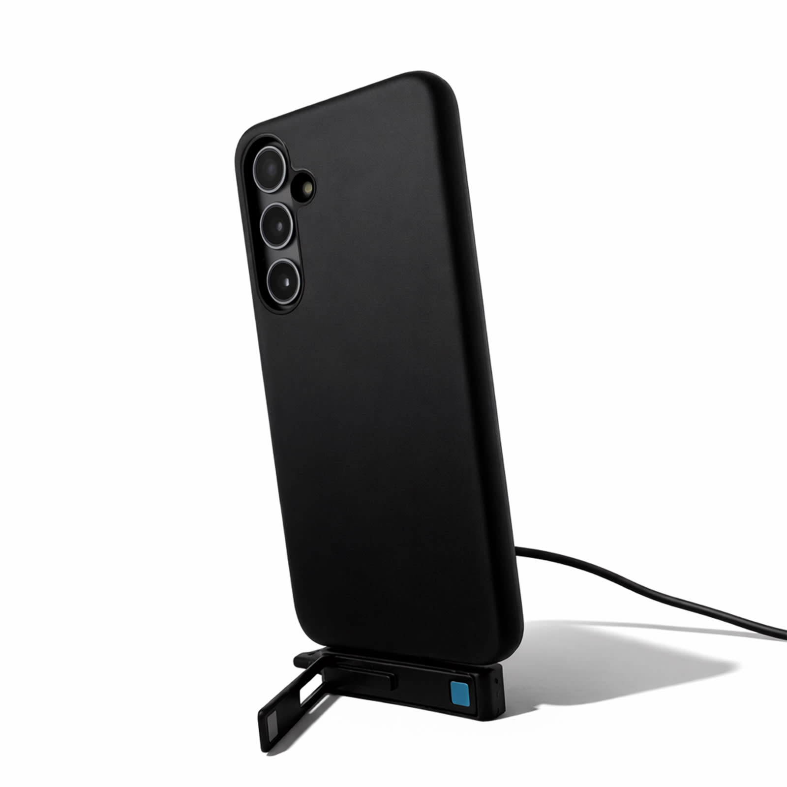 A black phone case with a built-in stand, featuring a charging cable connected to it.