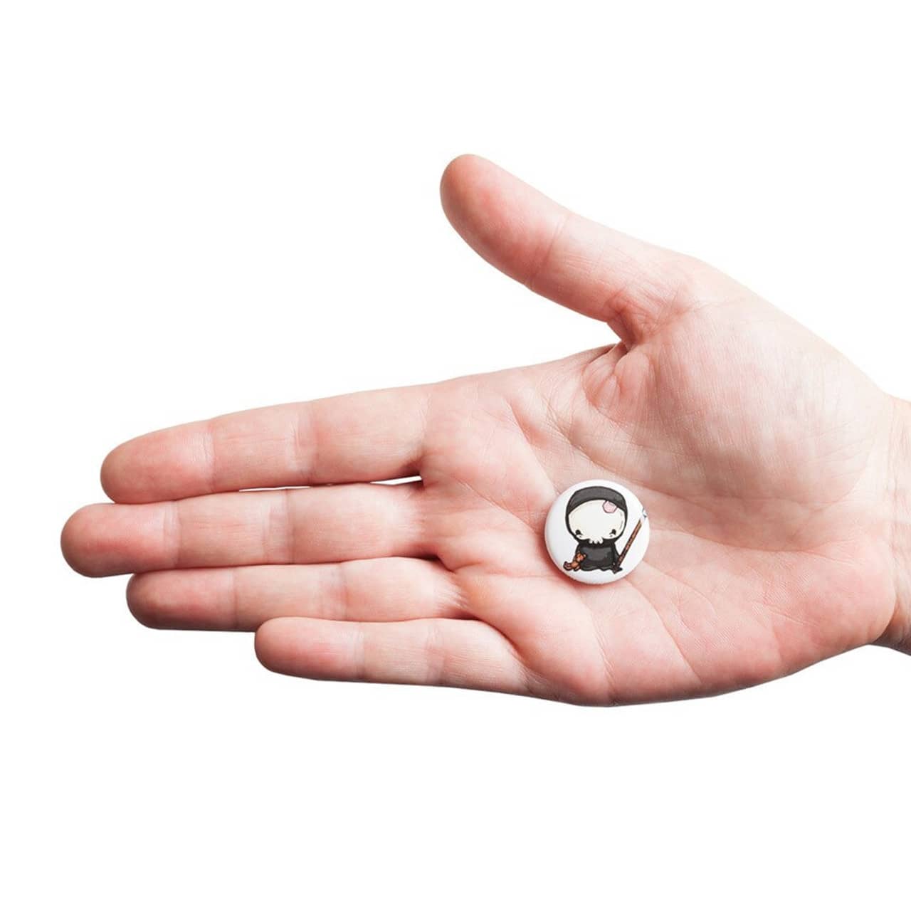 A hand holding a 25mm round badge featuring a small, illustrated character, set against a white background.
