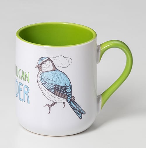 A coffee mug featuring a blue bird illustration with a green interior and handle. The mug also has a logo.