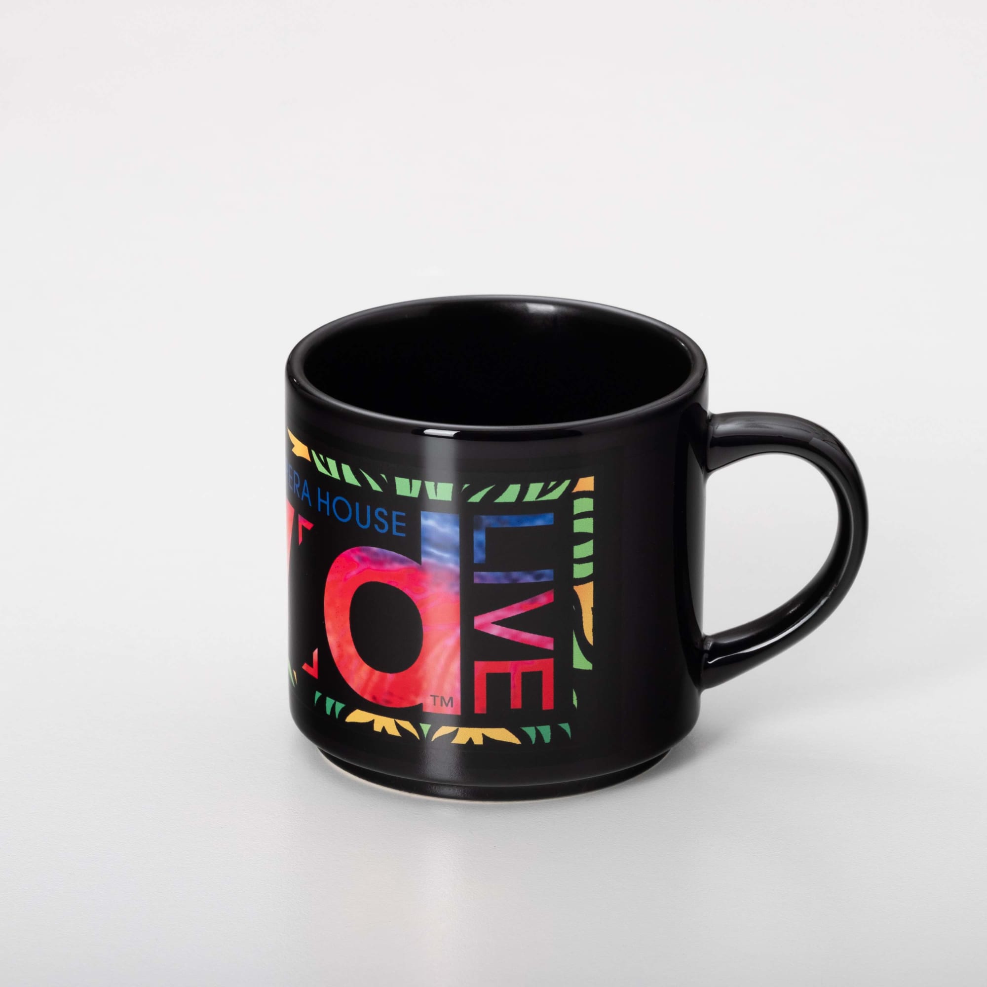 A black coffee mug featuring a vibrant, multicoloured design and a logo.