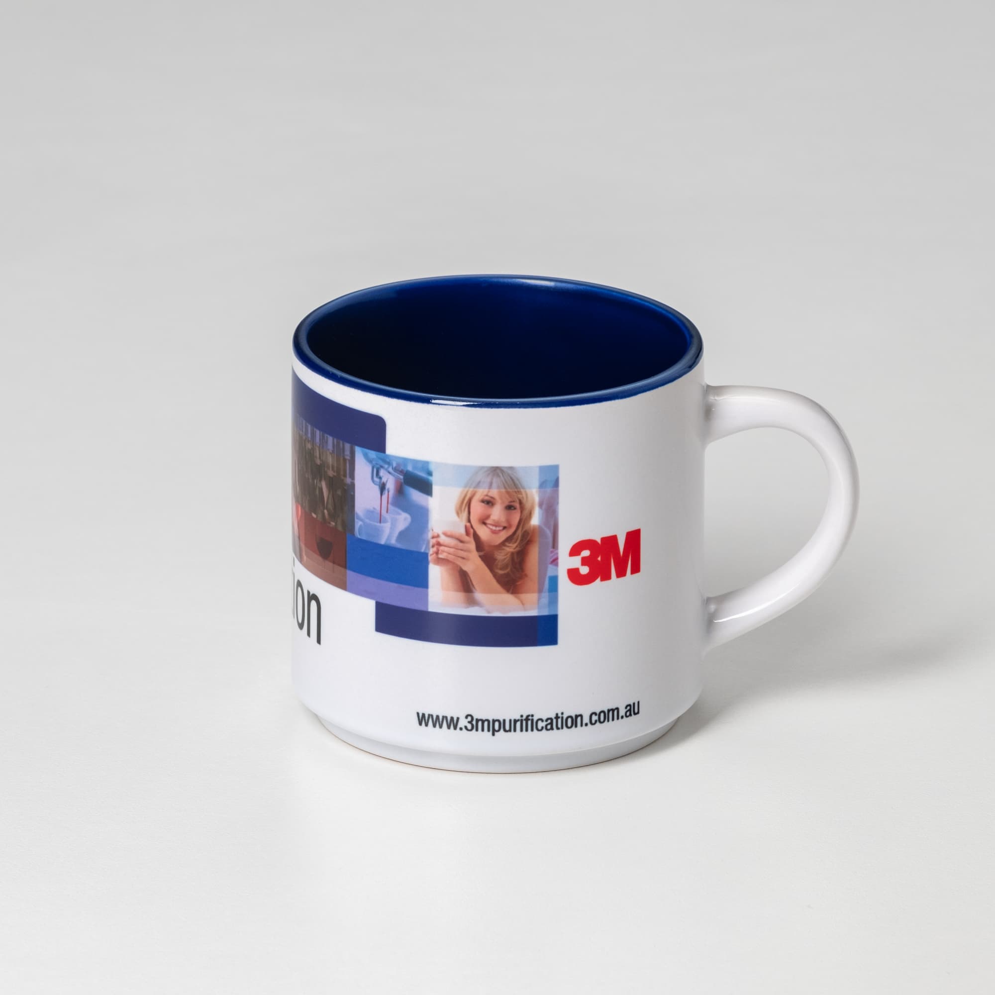 A coffee mug featuring a white exterior with a blue interior and a logo. It includes various images on the sides.