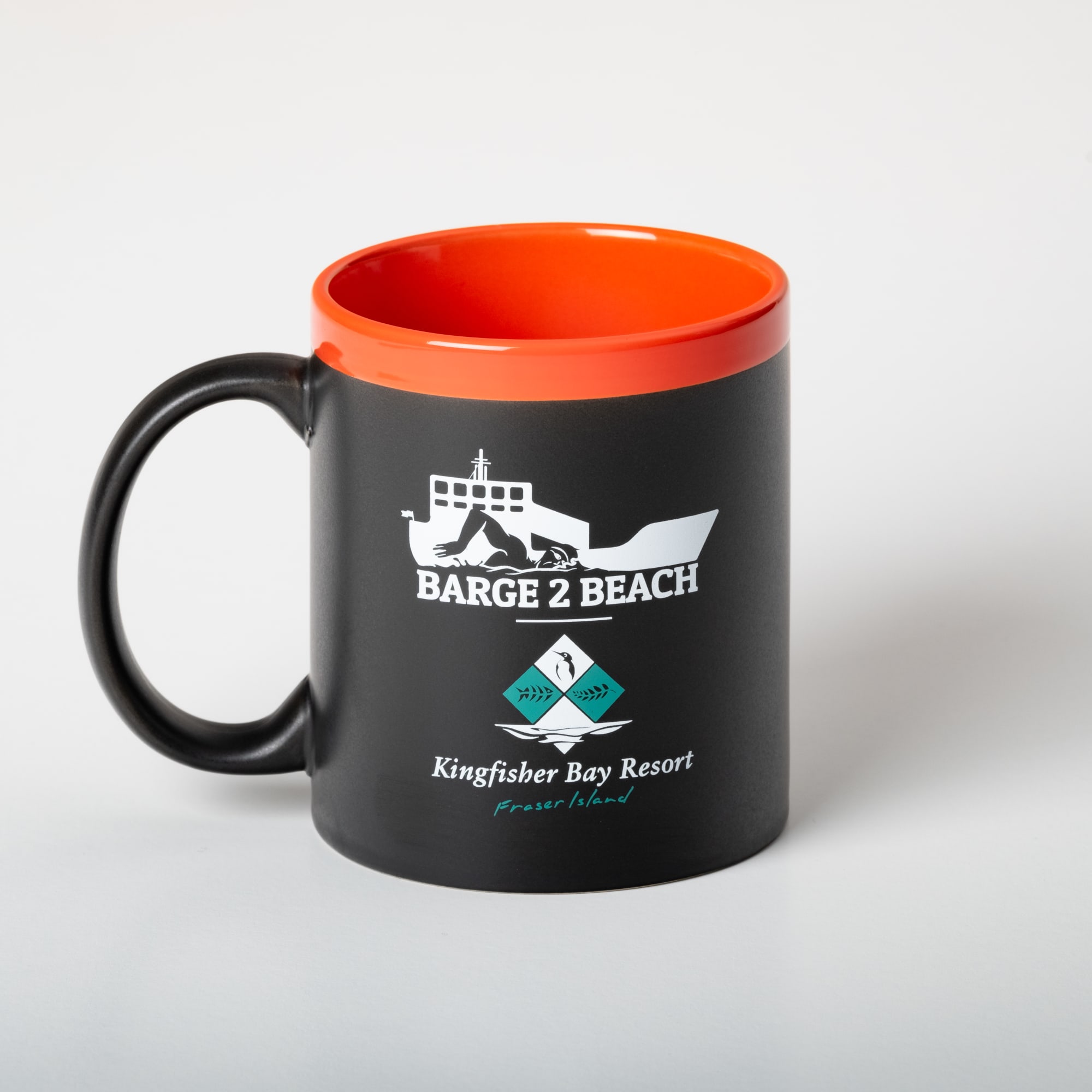 A coffee mug featuring a black exterior with an orange inner rim and a logo on the front.