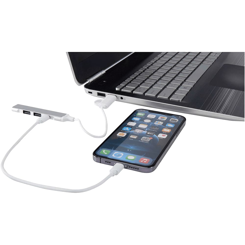 A 4-port USB hub in silver connects to a laptop with a phone attached, featuring USB-A and Type-C inputs.