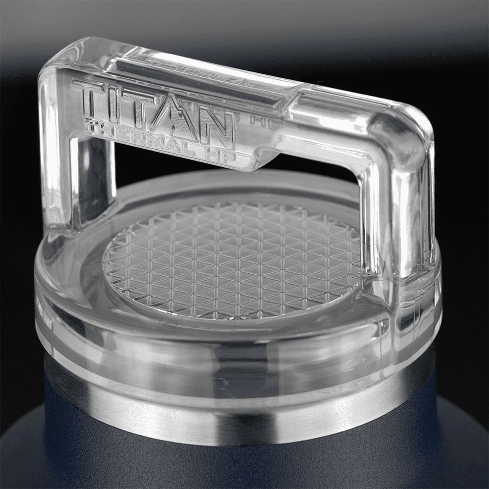 A drink bottle featuring a stainless steel base and a clear, hexagonal-patterned lid with a handle.