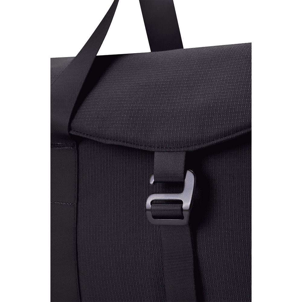 A black duffel bag with a textured finish and a clasp closure, featuring a strap for carrying.