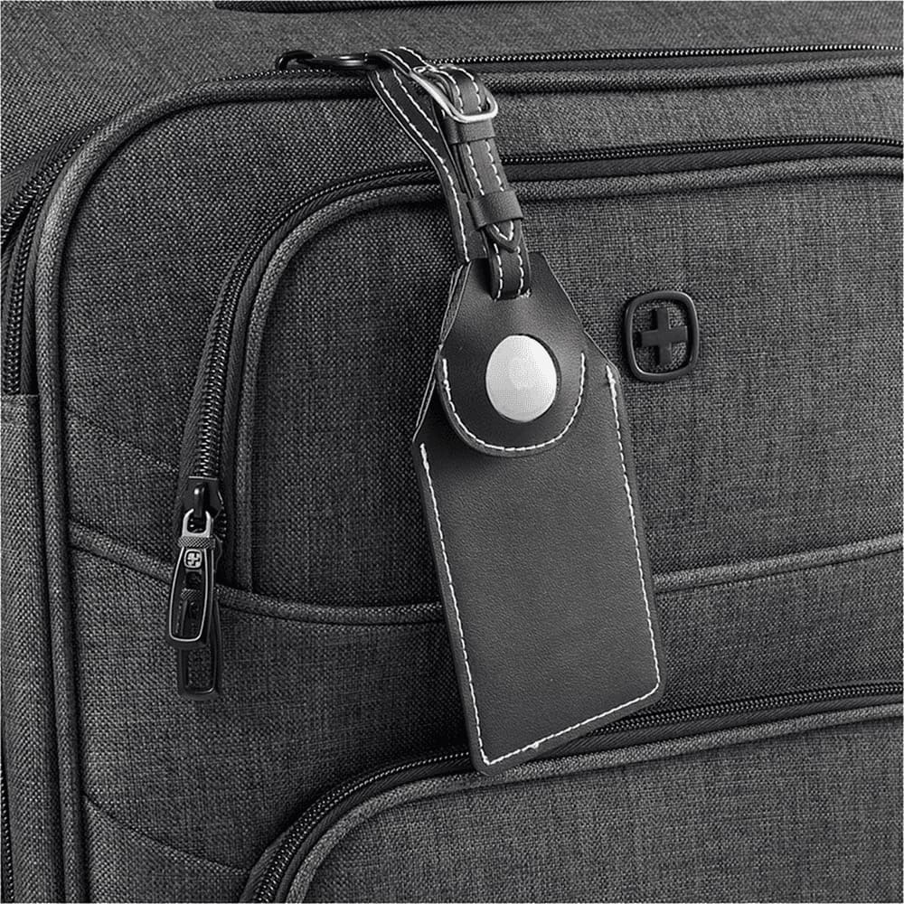 A black luggage tag with an AirTag holder attached to a grey suitcase, featuring a logo on the suitcase.