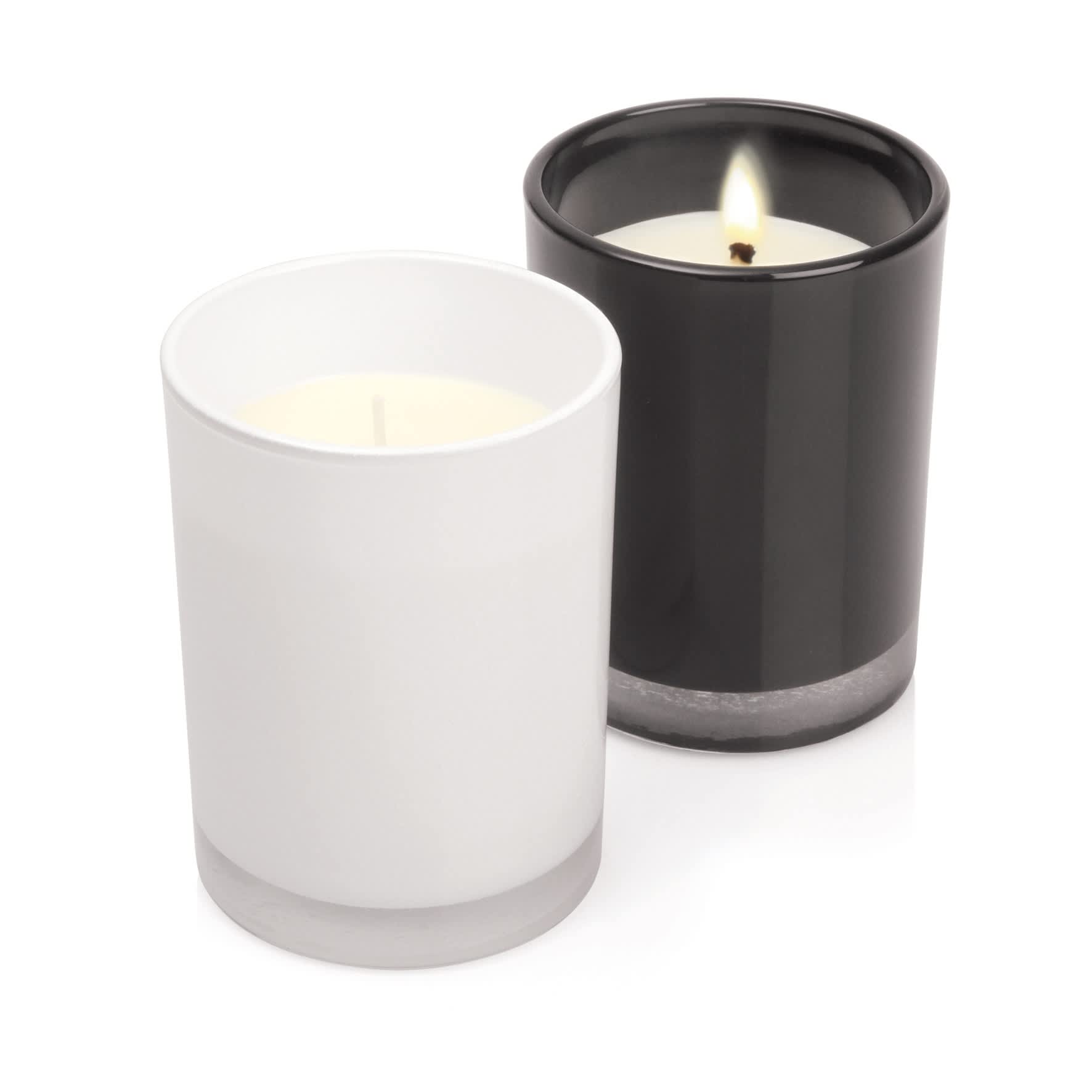 Two glass candles, one white and one black, featuring a minimalist design and a silver base.