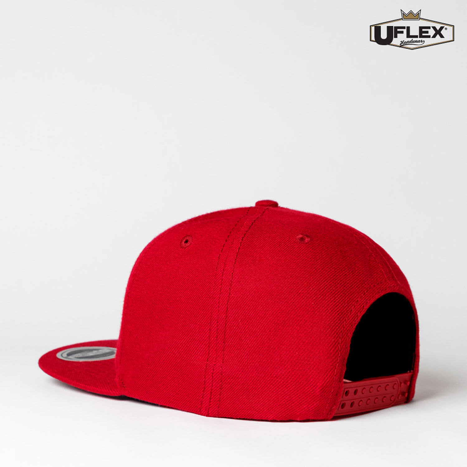 A red snapback cap with a rounded crown and a flat brim. It features a logo on the side.