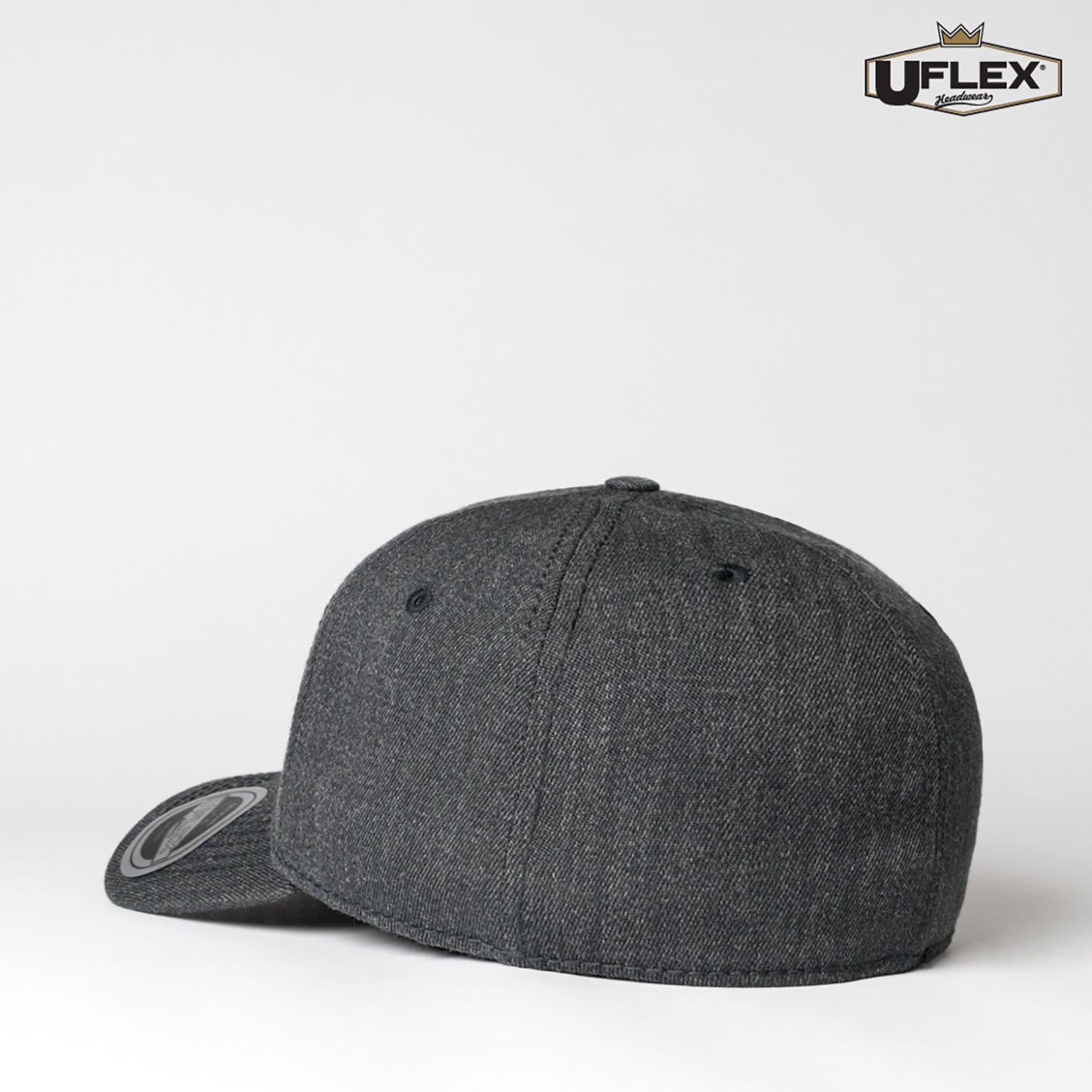 A dark grey fitted cap with a rounded peak and a logo on the side, showcasing a classic style.