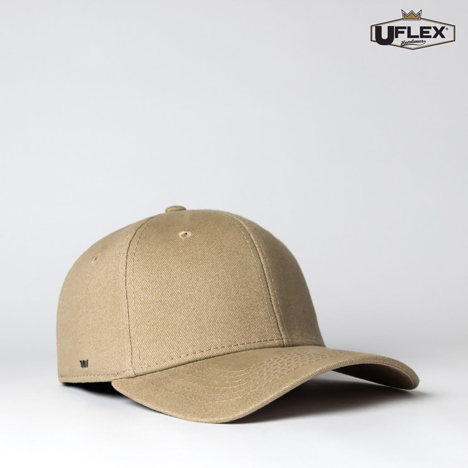 A fitted cap in a muted beige colour with a curved brim and a logo on the side.