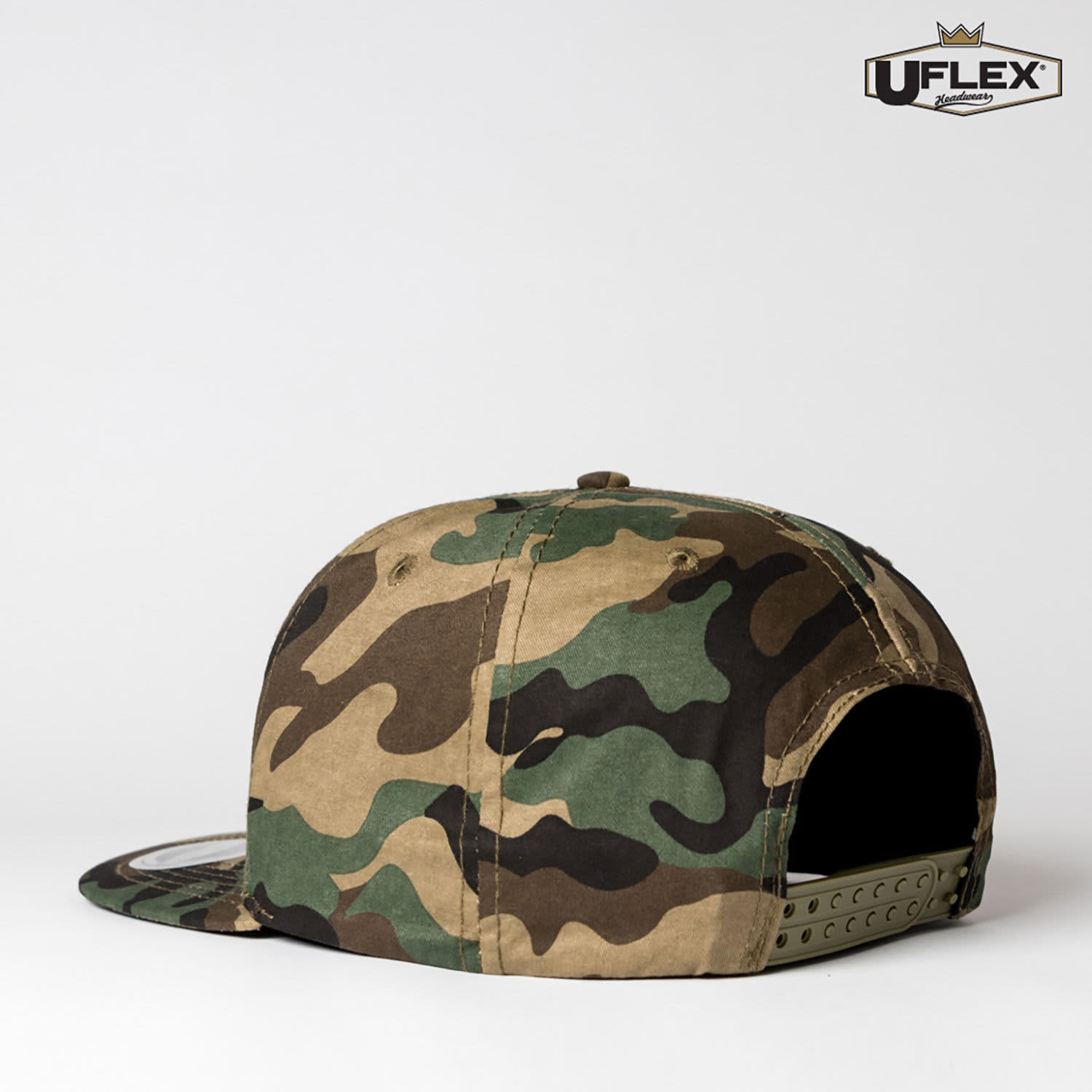 A camouflage snap back cap featuring a small logo and a flat brim. The colours include various shades of green and brown.