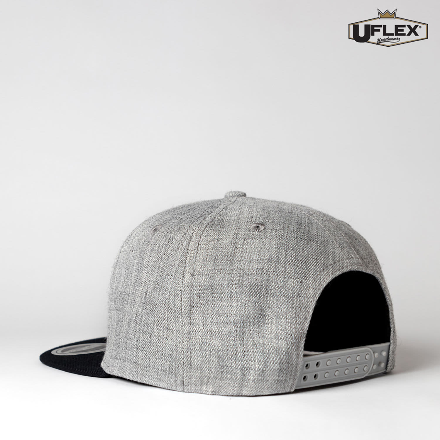 A grey and black snapback cap featuring a branded logo on the side and a structured design.