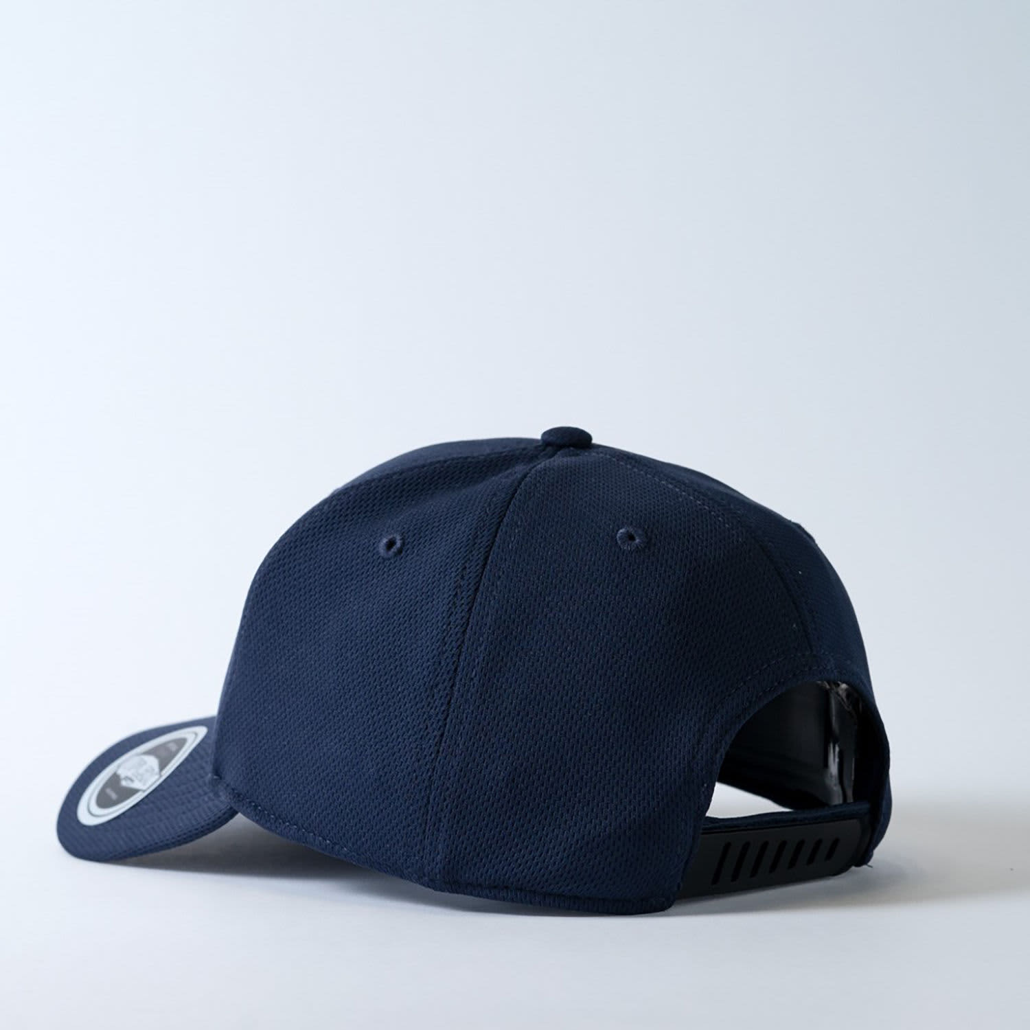 A navy recycled polyester cap with a mesh design and a branded logo on the side.