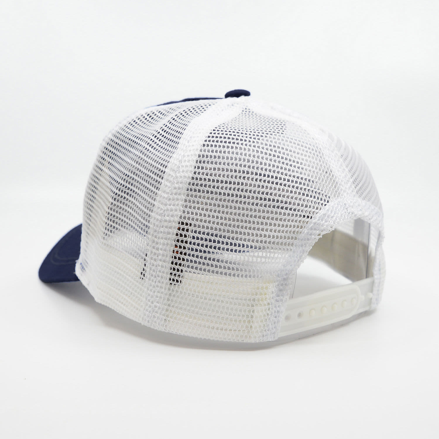 A navy blue trucker cap with a white mesh back and adjustable strap, featuring a logo on the front.
