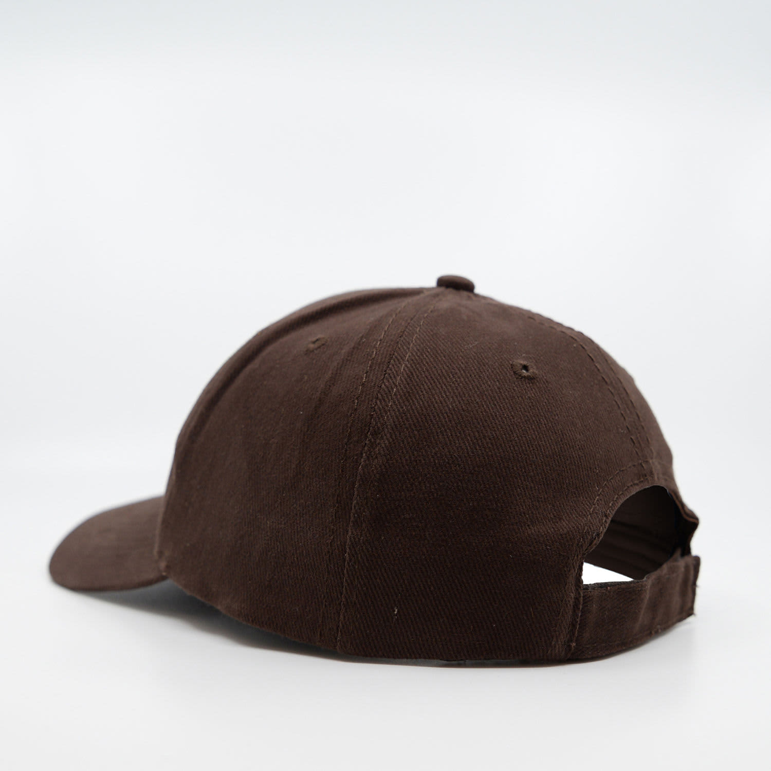 A brown six-panel cap made of brushed cotton, featuring a logo and an adjustable back strap.