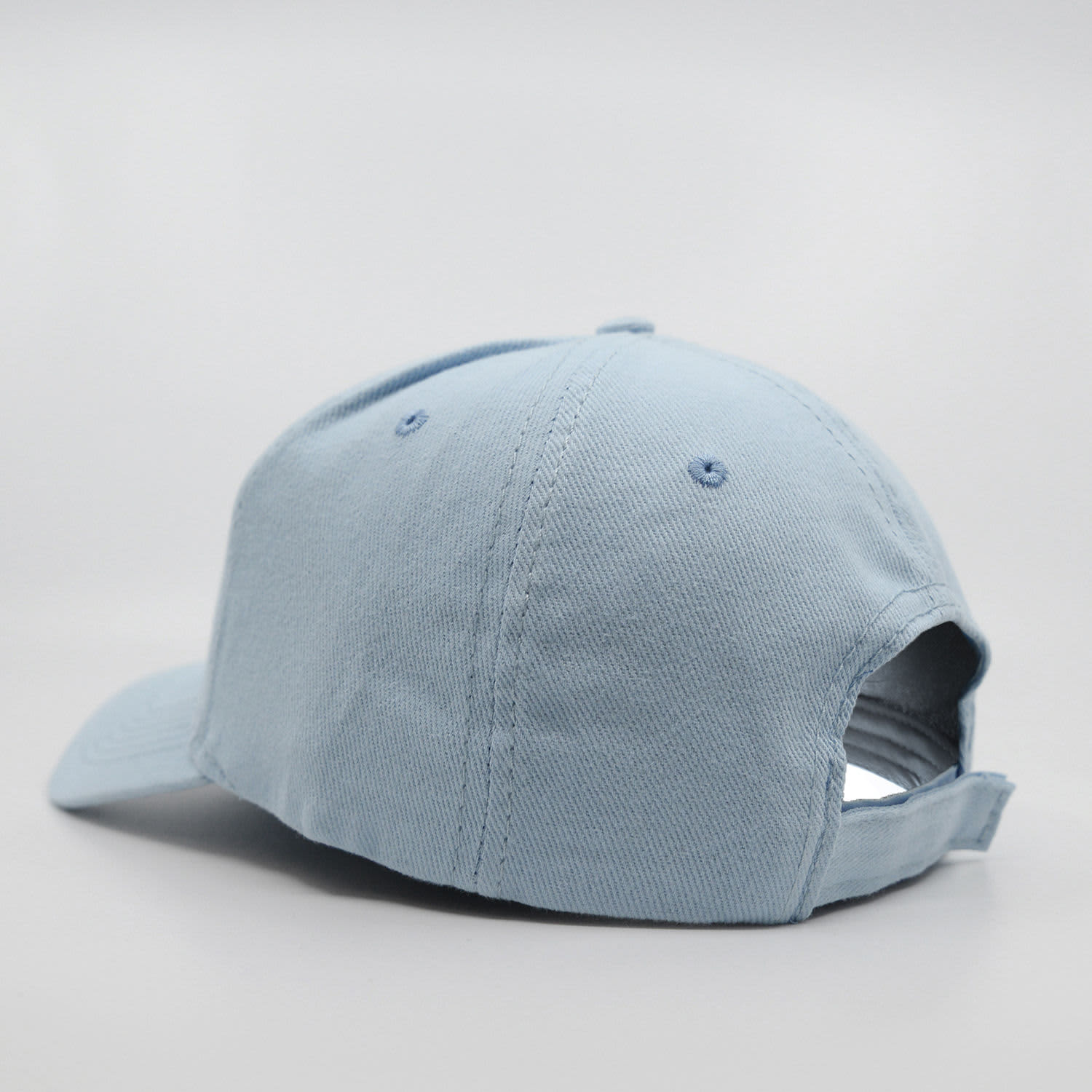 A light blue six-panel cap made of brushed cotton, featuring a back strap and a logo.