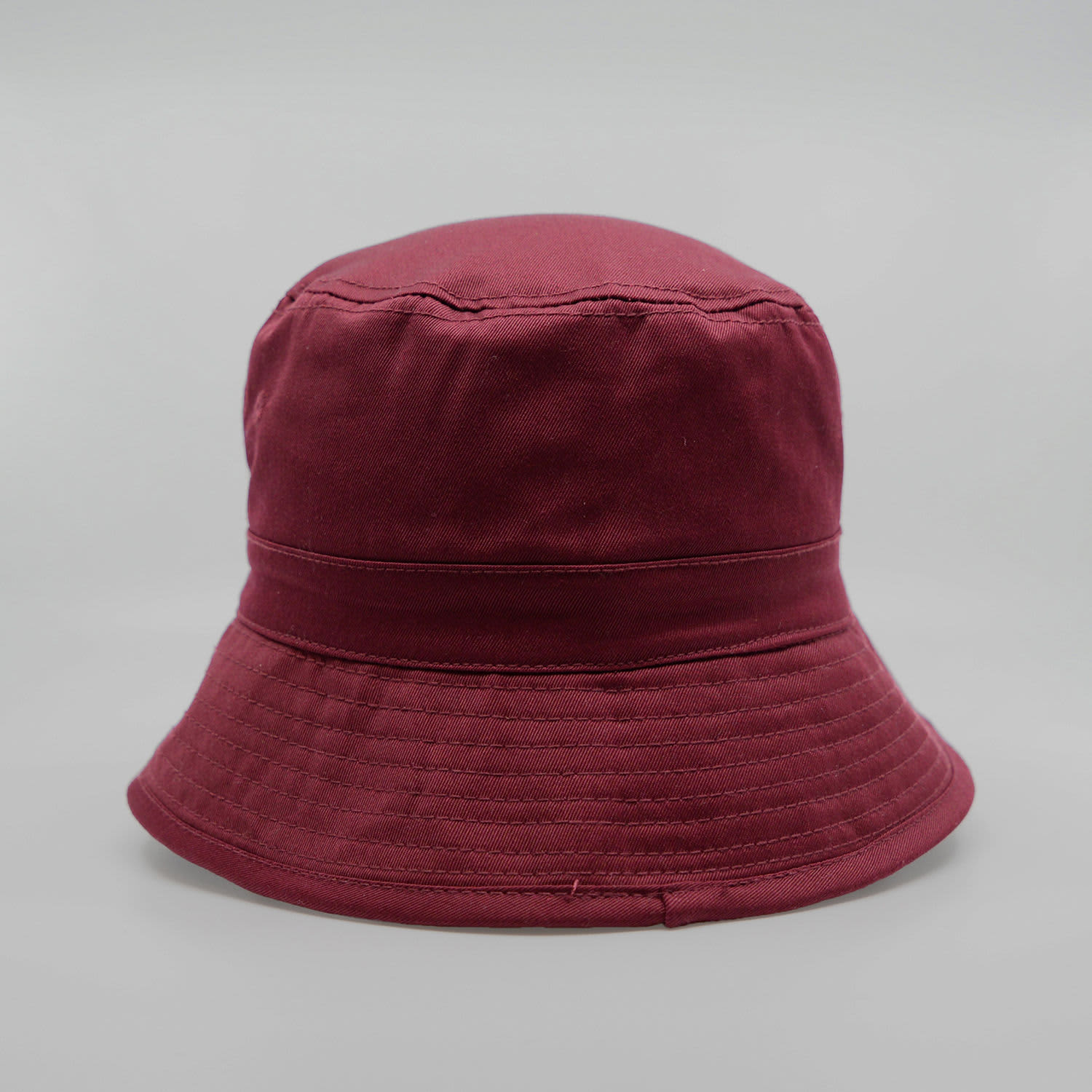 A maroon bucket hat featuring a rounded crown and a wide brim, with a logo on the side.