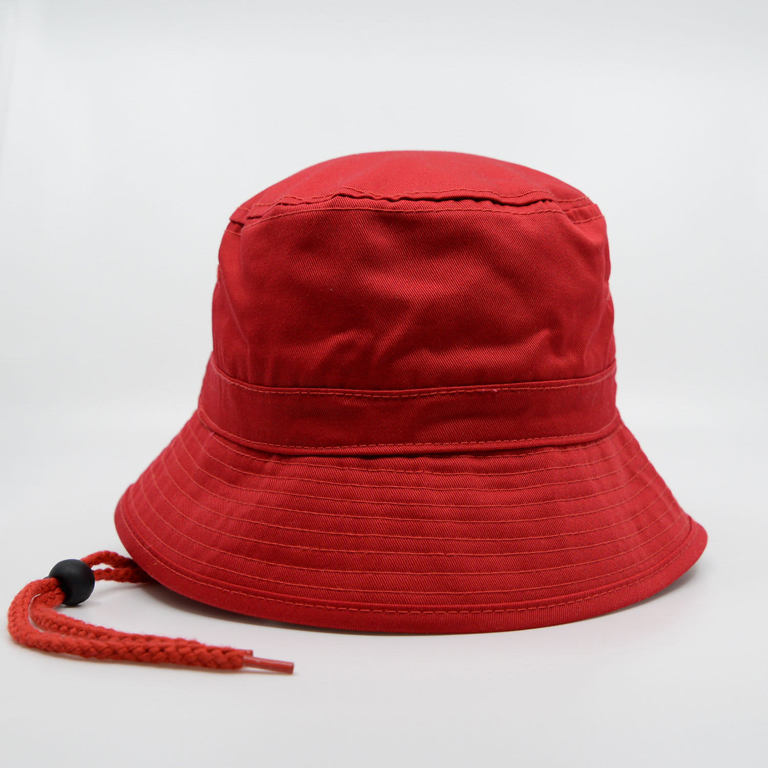 A red bucket hat featuring a textured brim and an adjustable drawstring. The hat includes a logo detail.