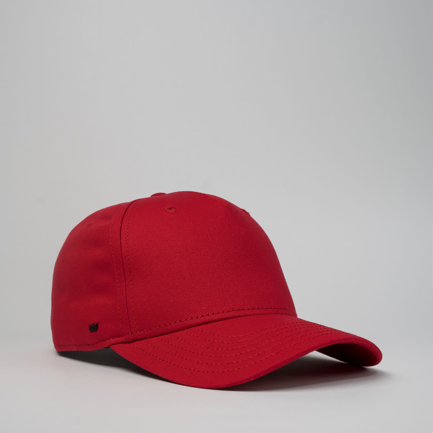 A red five-panel snapback cap with a structured design and a subtle logo.