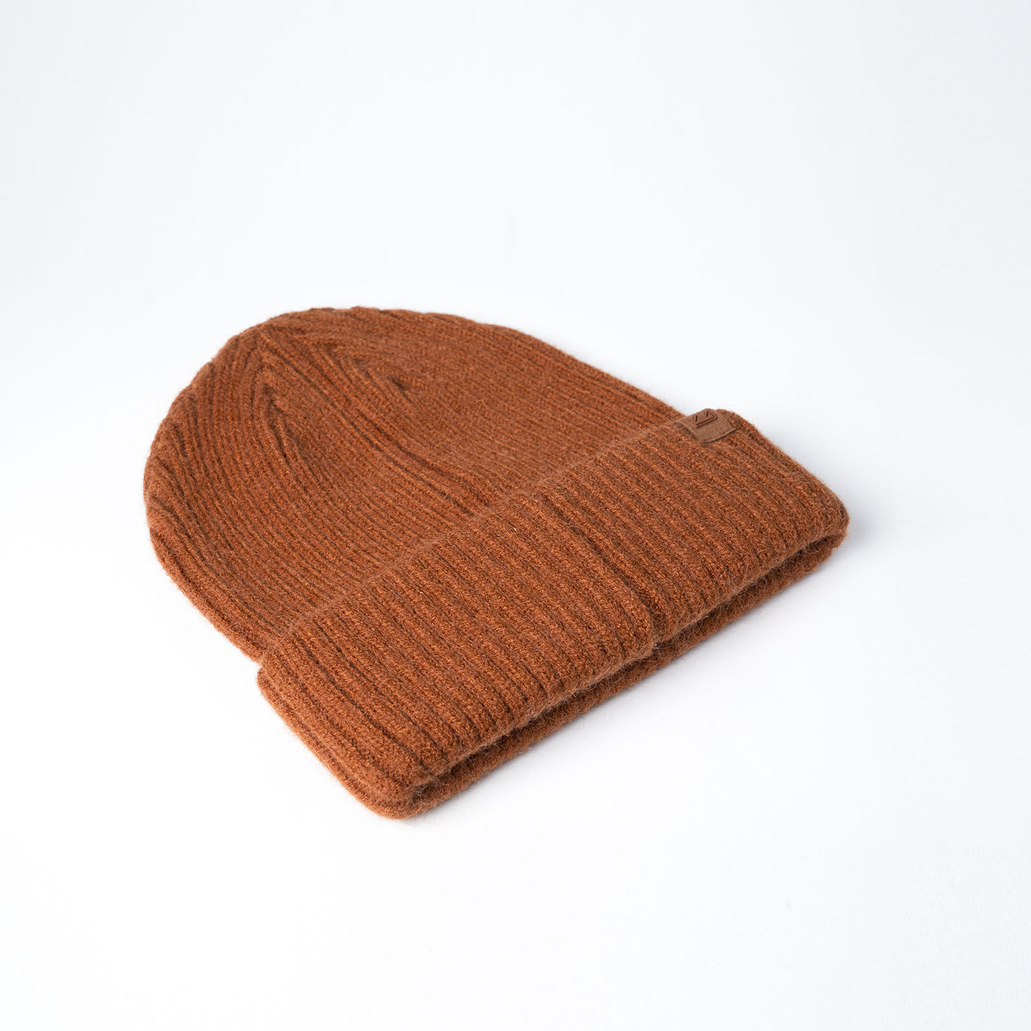 A brown fisherman's beanie with a ribbed texture and a folded cuff, featuring a small logo.