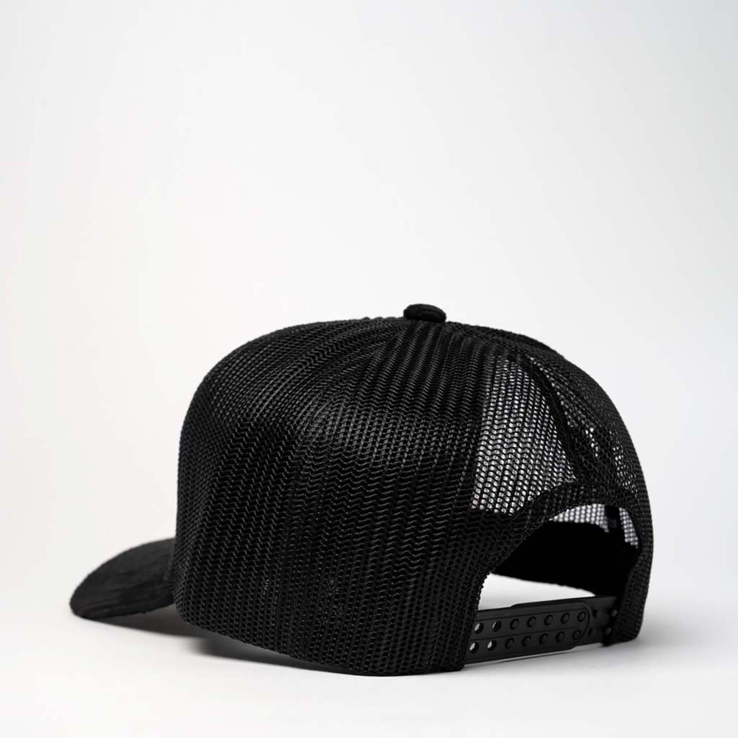 A black trucker snapback cap featuring a mesh back and adjustable strap. It has a logo on the side.