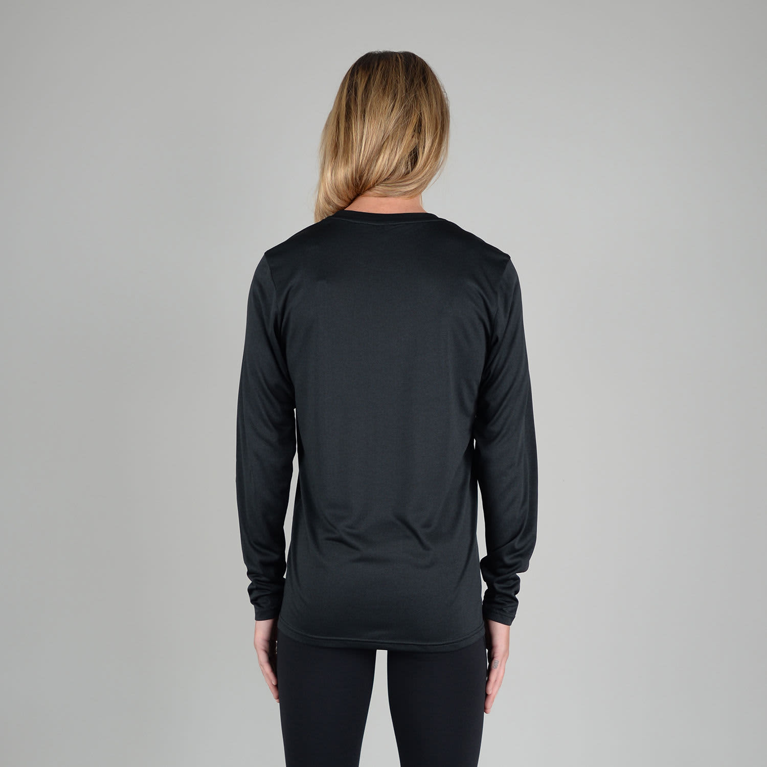A woman wearing a black long sleeve performance tee, viewed from the back. The shirt has a logo.