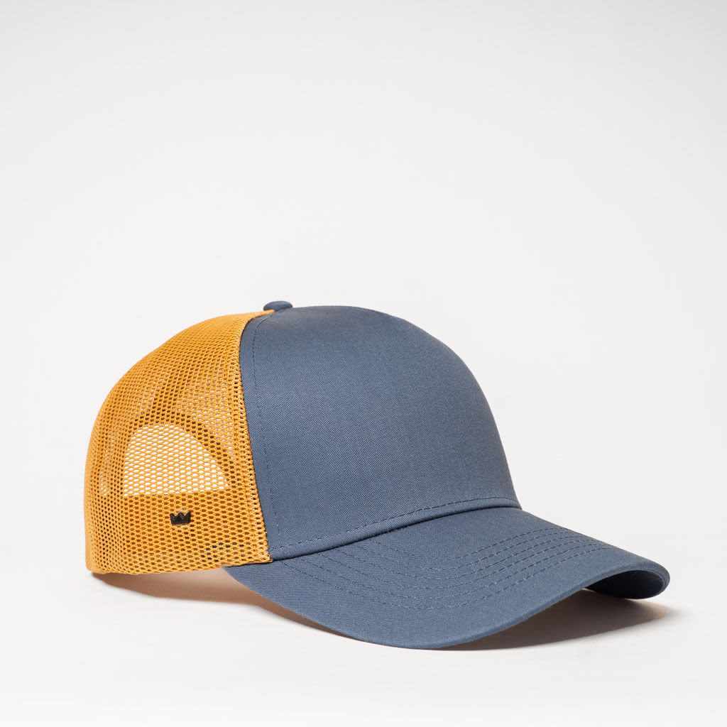 A trucker cap in navy blue and orange, featuring a mesh back and a logo on the side.