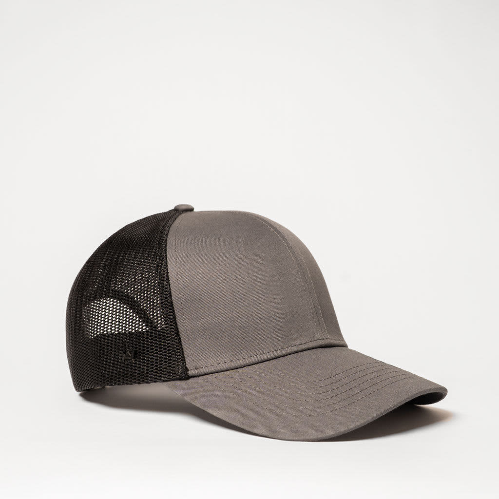 A grey trucker cap with a solid front and black mesh back, featuring a branding logo.
