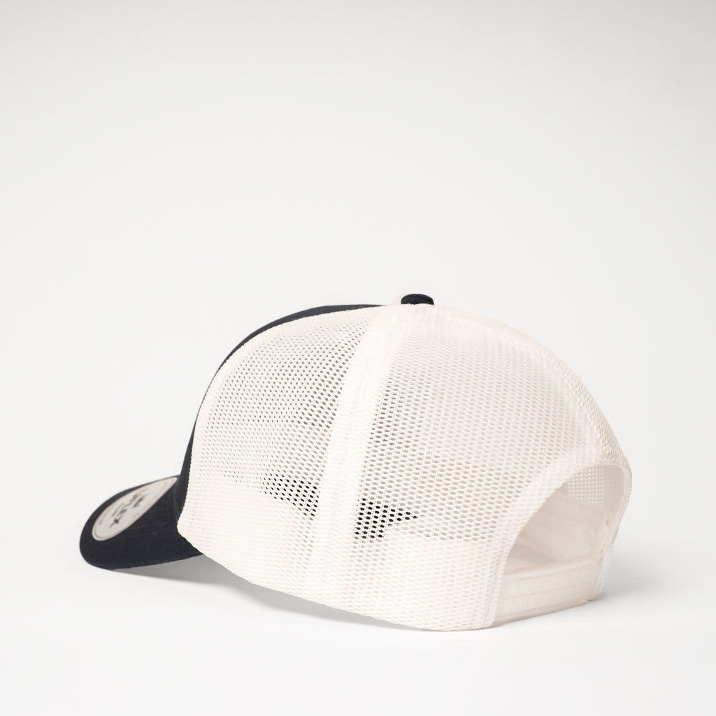 A navy and off-white UFlex Classic Ultra-lite 6 Panel Trucker Cap featuring a mesh back and a logo.