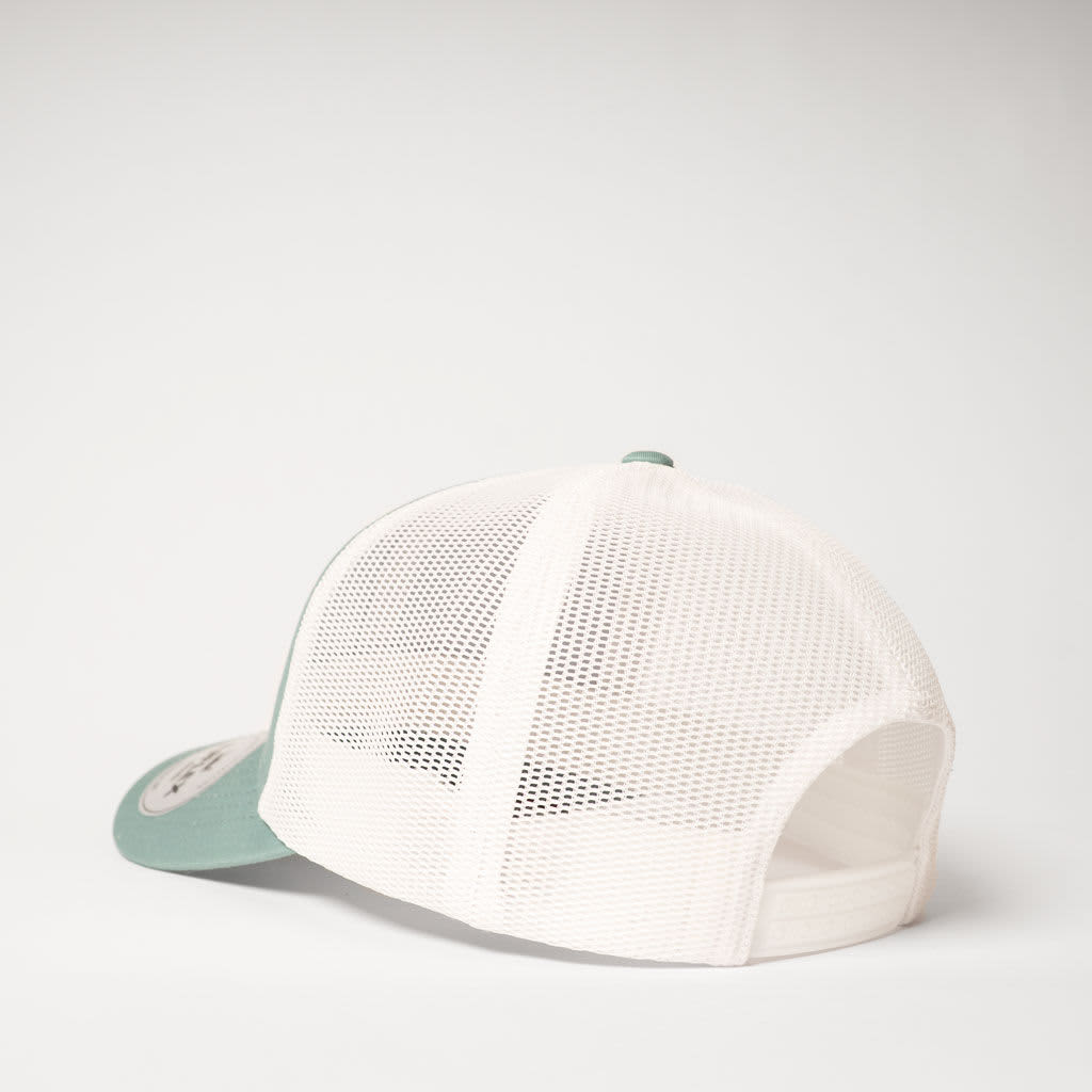 A green and white UFlex Classic Ultra-lite 6 Panel Trucker Cap featuring a mesh back and a logo.