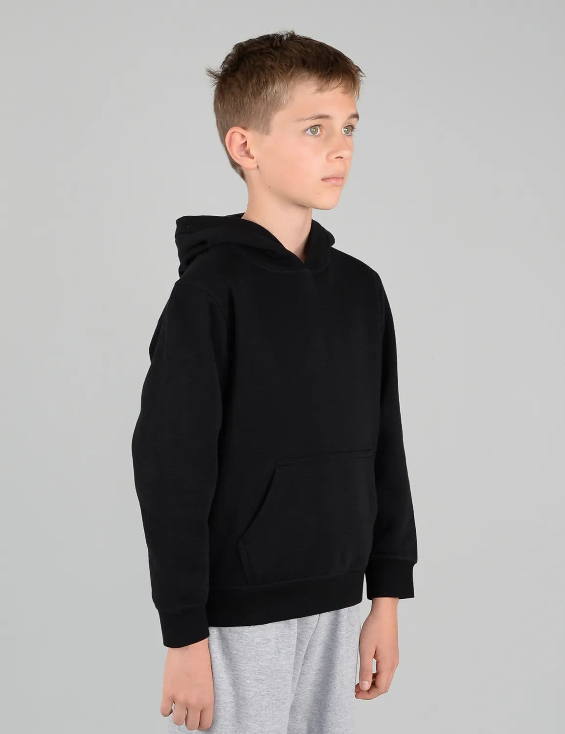 A black youth hoodie with a front pocket and a hood, displayed on a model in a neutral background.