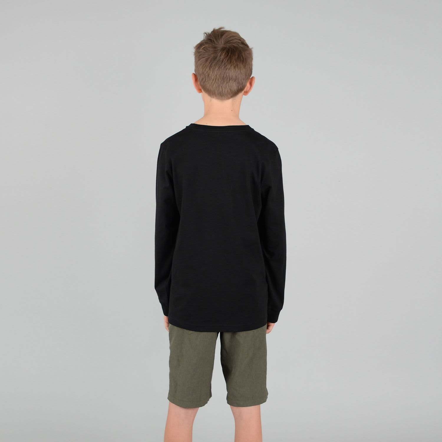 A black long sleeve youth tee is displayed, seen from the back, paired with green shorts. The shirt has a logo.