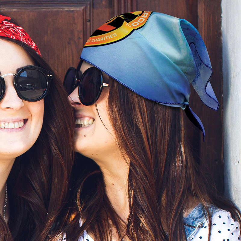 A triangle bandana in blue, worn by a woman with long brown hair, alongside another woman in a red bandana.