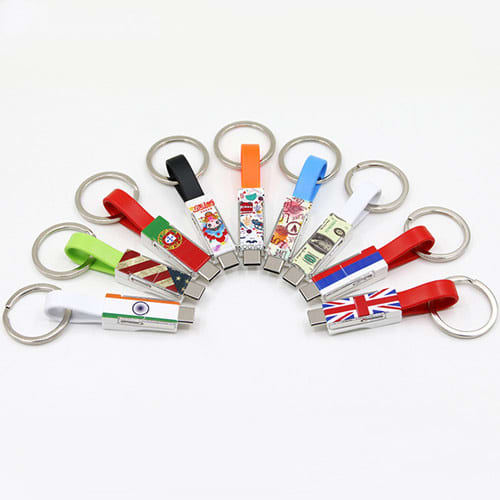 A collection of colourful keychain USB cables, featuring various designs and logos, arranged in a circular layout.