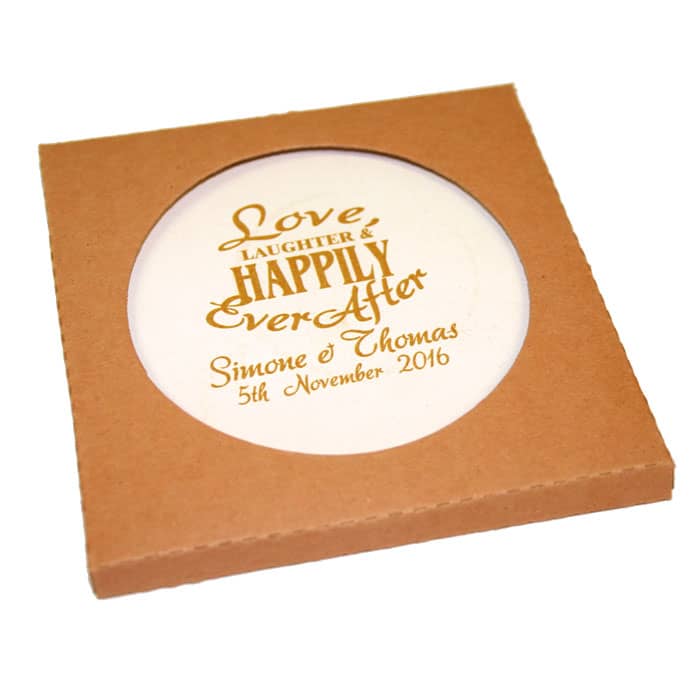 A round, cream absorbent stone coaster is presented in a brown cardboard box. Features decorative text and a logo.