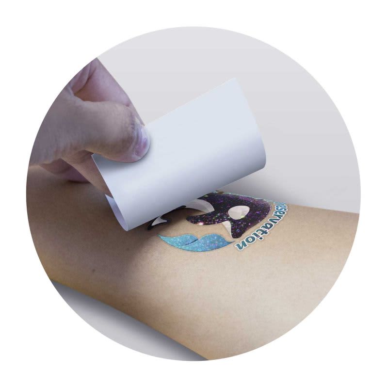 A glitter tattoo being applied to the skin, featuring a colourful design with a shimmering effect.