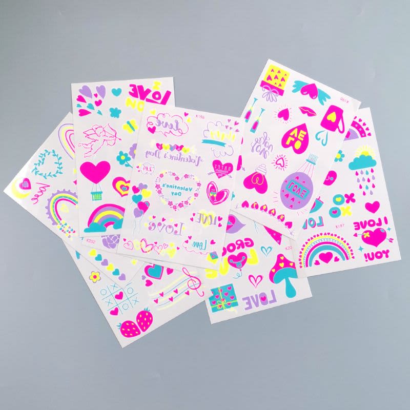 A collection of vibrant glow-in-the-dark temporary tattoos featuring hearts, rainbows, and various playful designs.