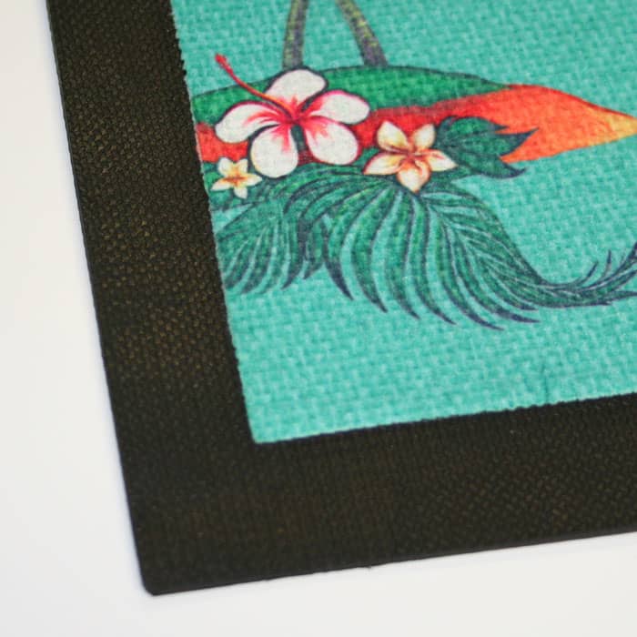 A bar runner featuring a vibrant tropical design with hibiscus flowers and green foliage on a textured background.