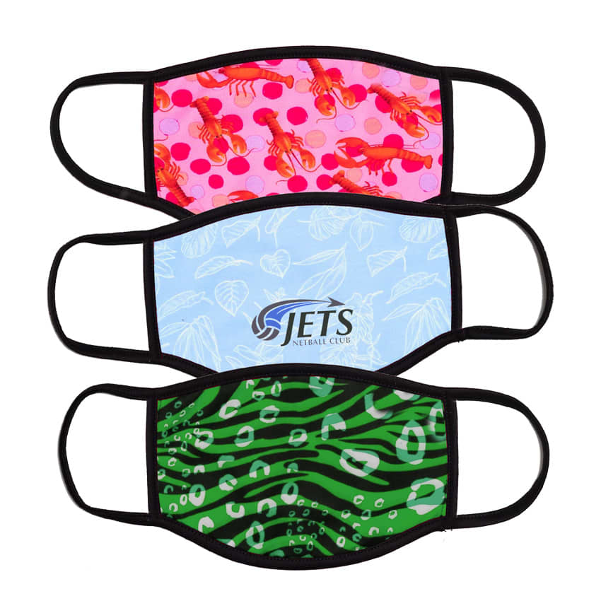 Three non-medical fabric face masks in pink with lobsters, light blue with leaves, and green with a leopard print design.
