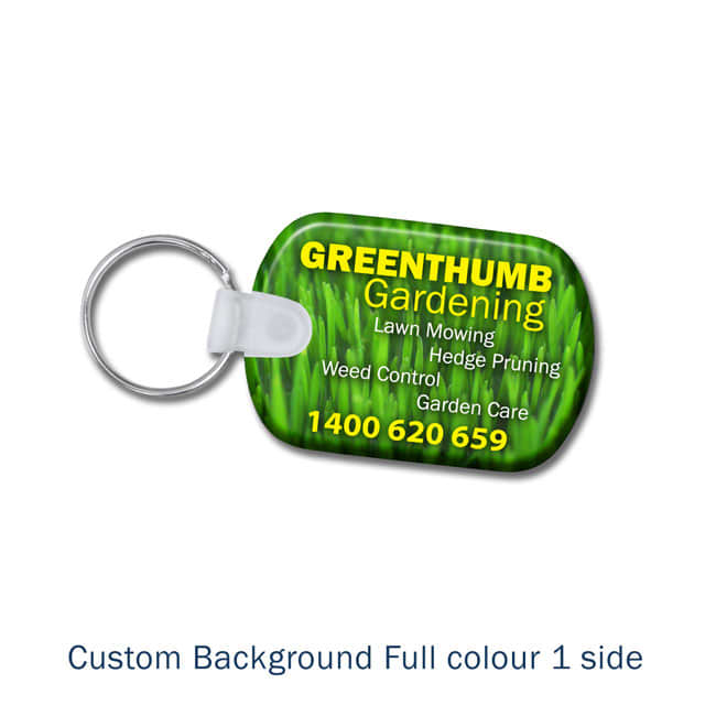 A keyring with a green grass background, featuring a logo and contact details for a gardening service.