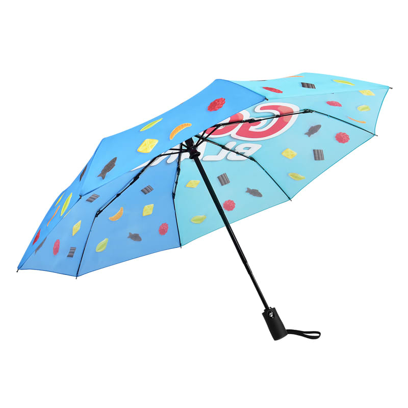 A compact umbrella featuring a light blue canopy adorned with colourful candy designs and a black handle.
