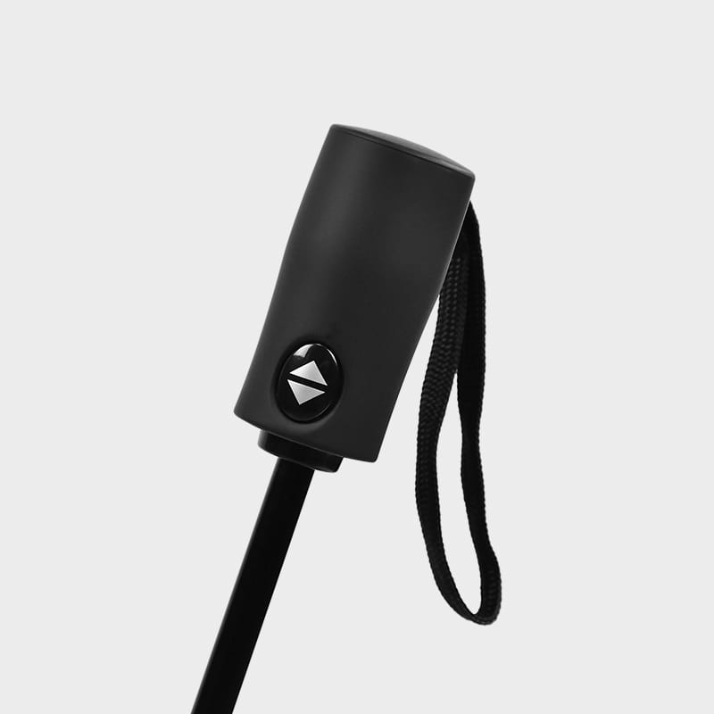 A compact umbrella handle in black with a strap and button detail. Features a sleek design.