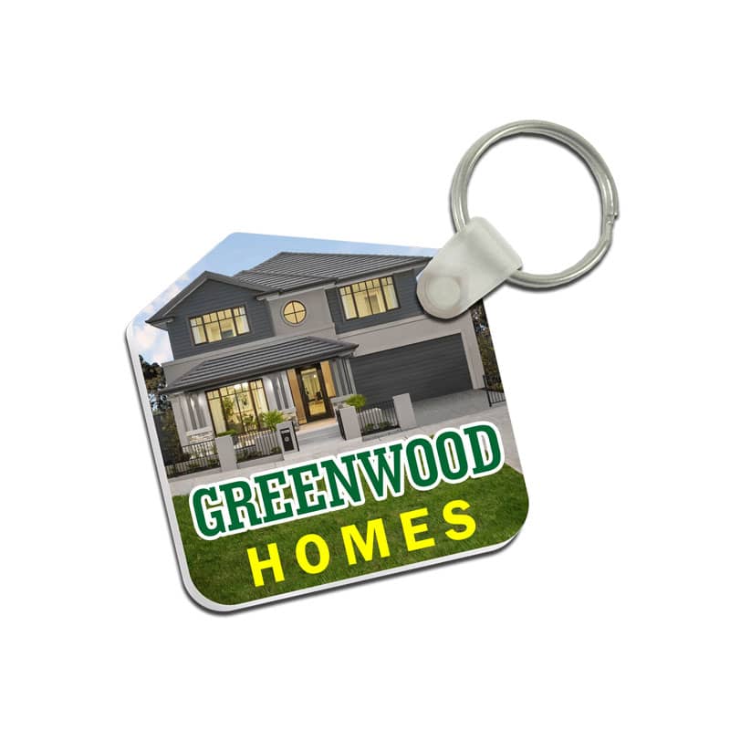 A custom-shaped acrylic keyring featuring a house design with green and yellow text and a metal keyring attachment.